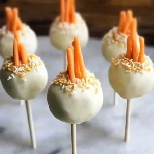Delicious carrot cake pops decorated with cream cheese frosting and sprinkles.