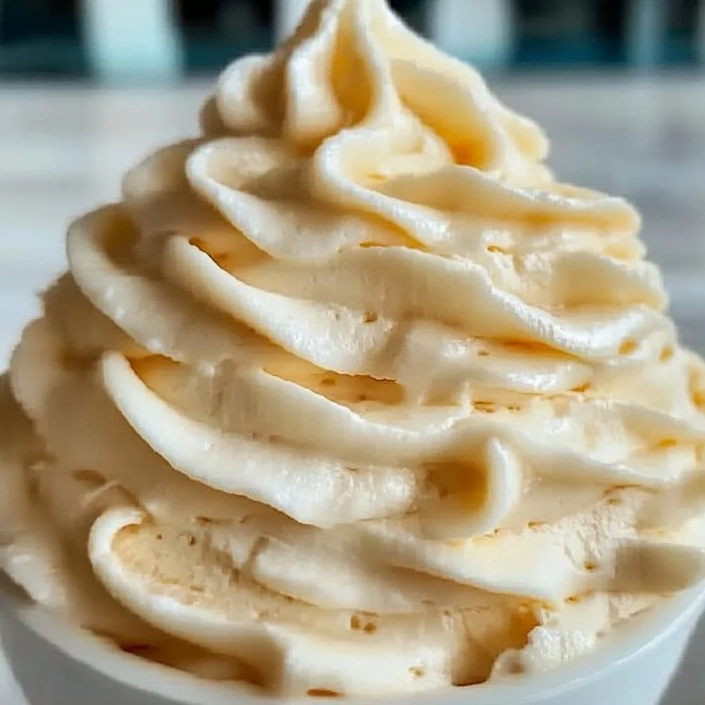 A bowl of smooth vanilla buttercream frosting perfect for cake decorating.