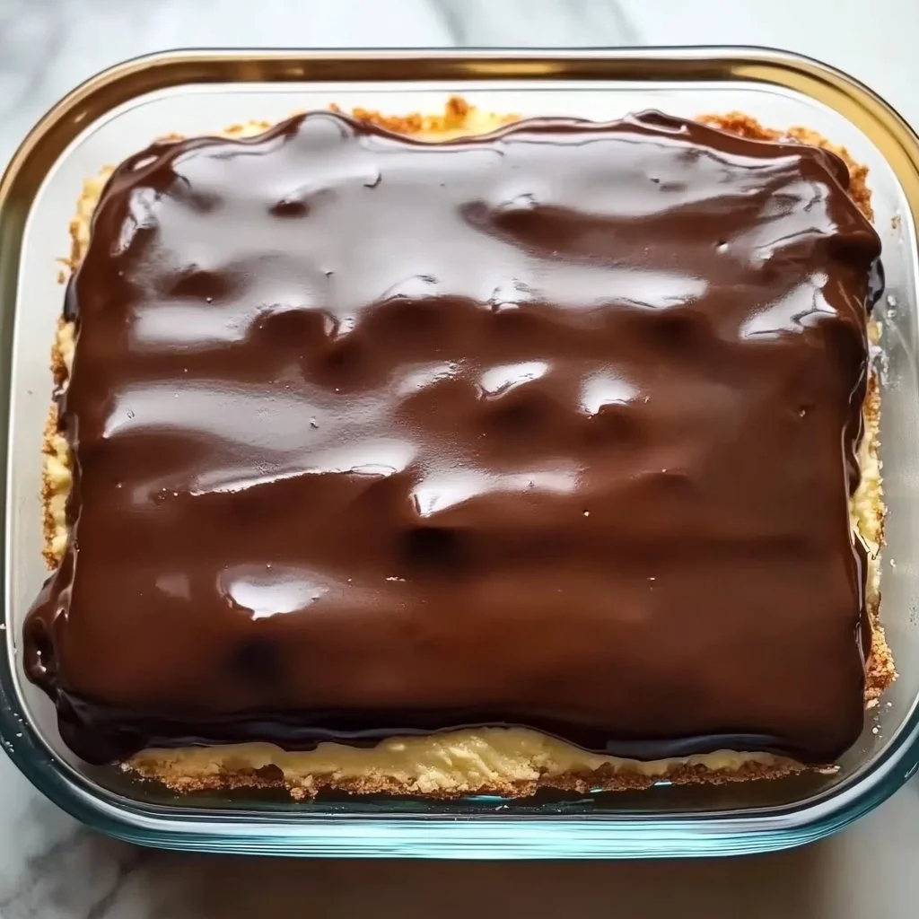 Delicious Boston Cream Pie Poke Cake with chocolate glaze and cream filling