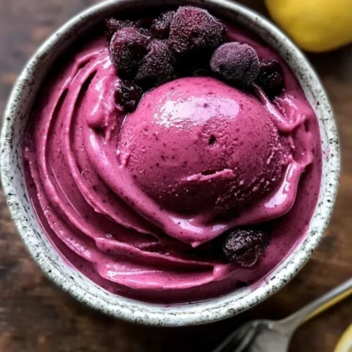 A bowl of vibrant Lemon Mulberry Sorbet topped with fresh berries