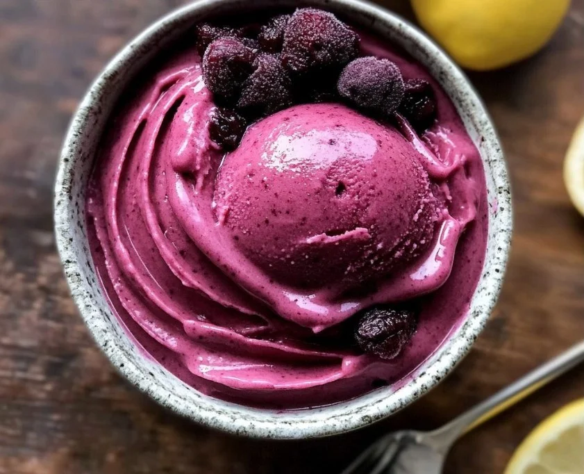 A bowl of vibrant Lemon Mulberry Sorbet topped with fresh berries
