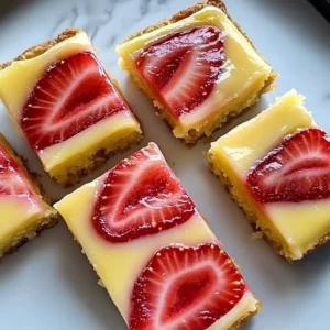 Delicious strawberry lemon bars on a plate with fresh strawberries and lemons.